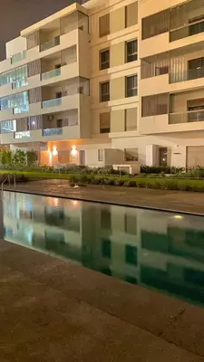 a building with a swimming pool in front of a building at Studio calme à Zenata in Aïn Harrouda