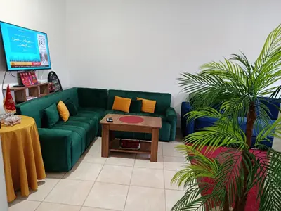 a living room with a green couch and a table at Cosy Bernoussi in Casablanca
