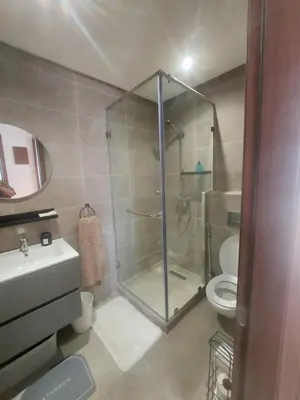 a bathroom with a glass shower and a toilet at Superbe duplex avec vue mer in Aïn Harrouda