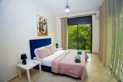 a bedroom with a bed and a large window at Villa avec piscine et sauna 8 chambres proche commodité et Casa Finance City in Casablanca