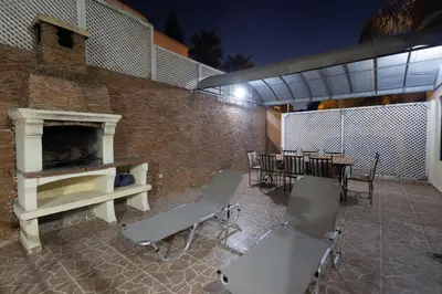 a patio with chairs and a brick wall with a fireplace at Villa avec piscine et sauna 8 chambres proche commodité et Casa Finance City in Casablanca