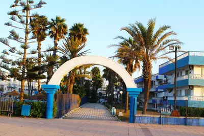 an archway with palm trees in front of a building at Palm beach in Mansouria in O Ben Slimane