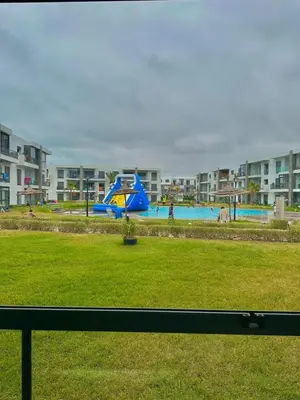 a playground with a blue slide in a park at Residence Bleu Dhalia in Sidi Rahal