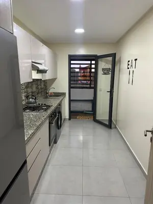 an empty kitchen with a door leading to an eat in kitchen at Residence Bleu Dhalia in Sidi Rahal