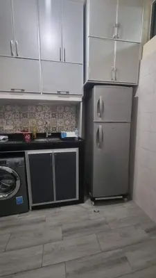 a kitchen with stainless steel appliances and white cabinets at Appartement Meublé avec Parking Gratuit, Calme & Pratique à Casablanca in Aïn Sebaa
