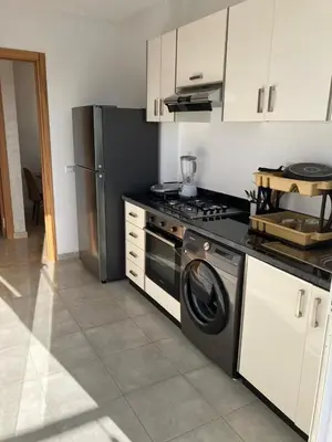 a kitchen with a stove and a refrigerator at Sunny 2-Bedroom Apartment with Pool for a Great Stay in Mohammedia