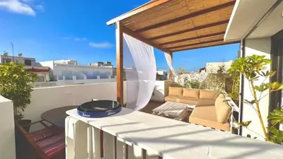 a balcony with a table and a couch on a roof at Duplex au centre de Rabat in Rabat