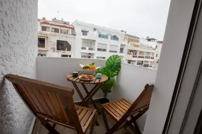 a balcony with two chairs and a table with a bowl of fruit at Duplex au centre de Rabat in Rabat
