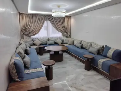 a living room with a blue couch and a table at Beautiful apartment 2 bedrooms living room aéroport mohamed 5 nouaceur Casablanca in Casablanca