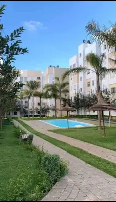 a park with a swimming pool and a building at Appartement avec Piscine à Tamaris, Confort, Vue Jardin et Plages à Proximité in Tamaris