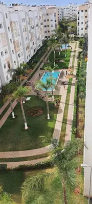 a view of a park with palm trees and a building at Appartement avec Piscine à Tamaris, Confort, Vue Jardin et Plages à Proximité in Tamaris