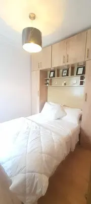 a bedroom with a large white bed with a light at Appartement avec Piscine à Tamaris, Confort, Vue Jardin et Plages à Proximité in Tamaris