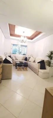 a white living room with couches and a chandelier at Appartement avec Piscine à Tamaris, Confort, Vue Jardin et Plages à Proximité in Tamaris