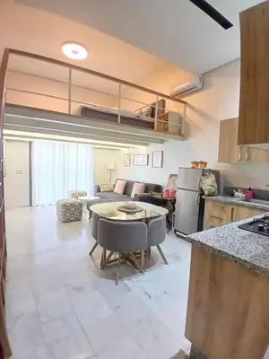 a kitchen and living room with a table in a room at Très beau studio Océan Park in Aïn Harrouda