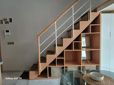 a wooden staircase in a room with a glass table at Très beau studio Océan Park in Aïn Harrouda