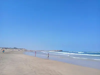 a group of people standing on a beach at Très beau studio Océan Park in Aïn Harrouda