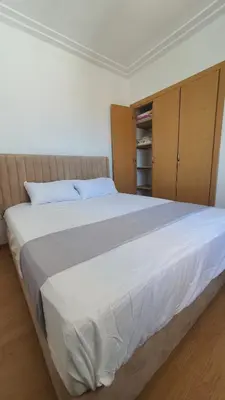 a bedroom with a large white bed with wooden cabinets at Ocean View Tamaris in Tamaris