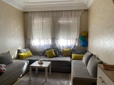 a living room with a gray couch and yellow pillows at Bedroom for girls only in Casablanca