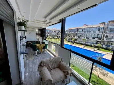 a living room with a large balcony with a pool at Appartement à louer in Nouaceur