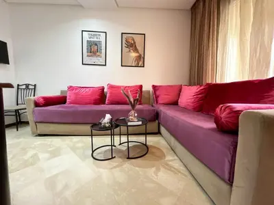a living room with a purple couch and a table at Central Studio Casablanca in Casablanca