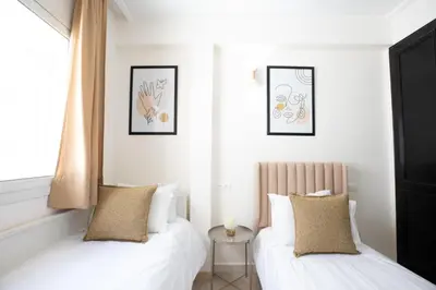 two beds in a room with white walls at Appartement Luxueux pour Famille - Quartier Abdelmoumen in Casablanca