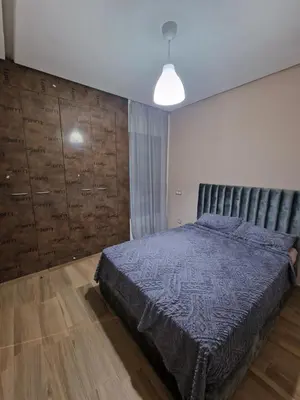 a bedroom with a bed and a wooden wall at Résidence blue beach Sidi rahal in Sidi Rahal