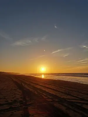a sunset on a beach with the ocean at Résidence blue beach Sidi rahal in Sidi Rahal