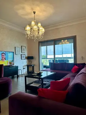 a living room with a couch and a chandelier at Appartement Blanca Beach in Sidi Rahal