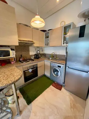 a kitchen with a refrigerator and a washing machine at Appartement Pied dans l'eau avec terrasse-Casa bay in Sidi Rahal