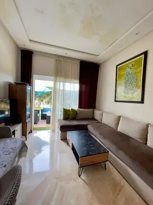 a living room with a couch and a table at Appartement Pied dans l'eau avec terrasse-Casa bay in Sidi Rahal