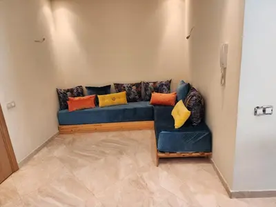 a blue couch with colorful pillows sitting in a room at LES JARDINS DE BOUZNIKA PREMIUm in Bouznika