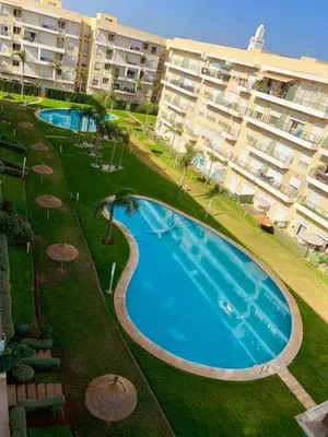 an overhead view of a swimming pool in front of a building at LES JARDINS DE BOUZNIKA PREMIUm in Bouznika