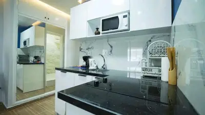 a kitchen with white cabinets and a microwave at Luxe Bleu Studio Rabat in Rabat