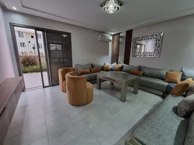 a living room with a couch and a table and chairs at Eden Prestige in Bouznika