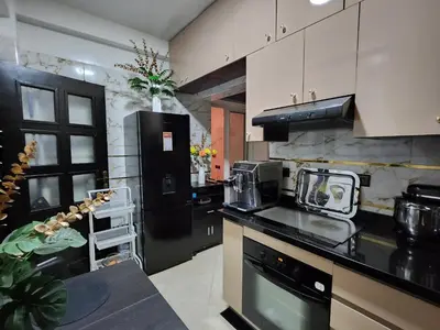 a kitchen with black and white cabinets and a counter top at Chambre pour une femme ou pour un couple dans un Appartement de luxe bien situé et bien équipé in Rabat