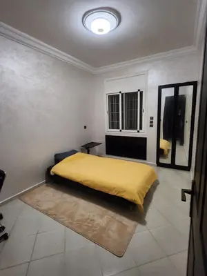 a bedroom with a bed with a yellow blanket at Chambre pour une femme ou pour un couple dans un Appartement de luxe bien situé et bien équipé in Rabat