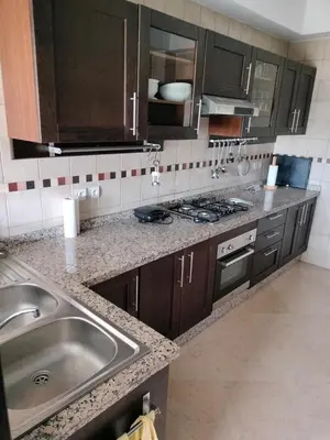a kitchen with a sink and a stove at Appartement meublé in Temara