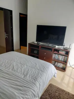 a bedroom with a bed and a flat screen tv at Appartement meublé in Temara