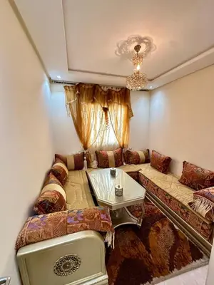 a living room with a couch and a table at Bel appartement vue piscine in Bouznika