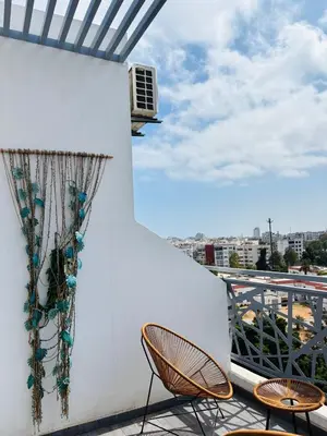 a balcony with two chairs and a window at Bright & Cozy Apt with City View in Casablanca