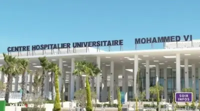 a large building with palm trees in front of it at A coté hôpital M6,Proche d'Aéroport et la gare bouskoura in Bouskoura