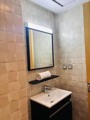 a bathroom with a sink and a mirror at Charming Apartment With City View in Casablanca