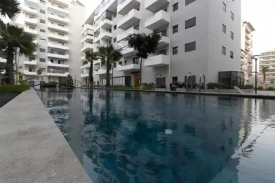 a swimming pool in front of a building at Cozy studio with great pool views in Aïn Harrouda