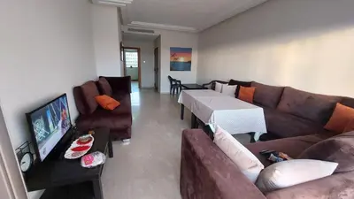 a living room with a couch and a tv at Jumeirah in Sidi Rahal