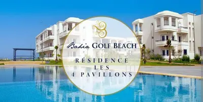a sign next to a swimming pool in front of a building at Appartement BAHIA BEACH piscine plage privée in Bouznika