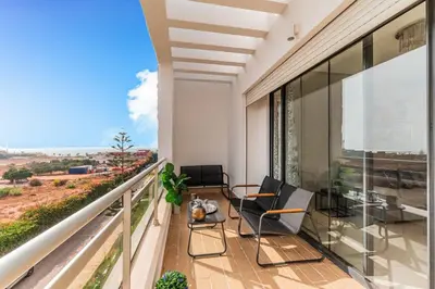 a balcony with two chairs and a view of the desert at L'Eden - 2 BR - Beachfront & Pool - 3 beds in Tamaris