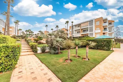 a park with palm trees and a building at L'Eden - 2 BR - Beachfront & Pool - 3 beds in Tamaris