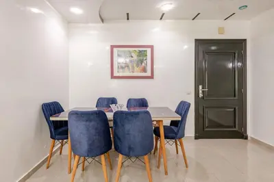 a dining room with a table and blue chairs at Apartment with sea view in Mohammedia