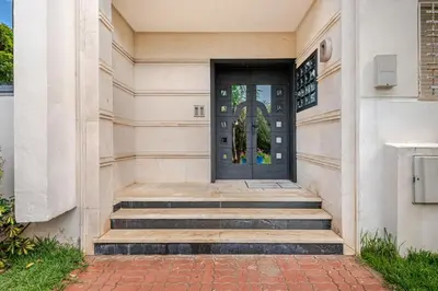 a black door on a white building with stairs at Apartment with sea view in Mohammedia