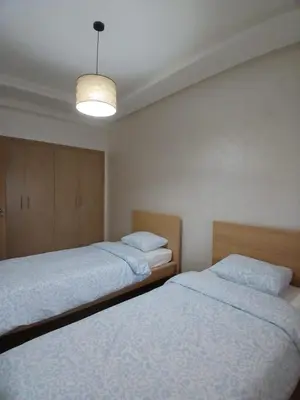a bedroom with two beds and a light at Duplex Luxe 3 Chambres Vue Mer & Piscine à Zenata Eco City in Aïn Harrouda